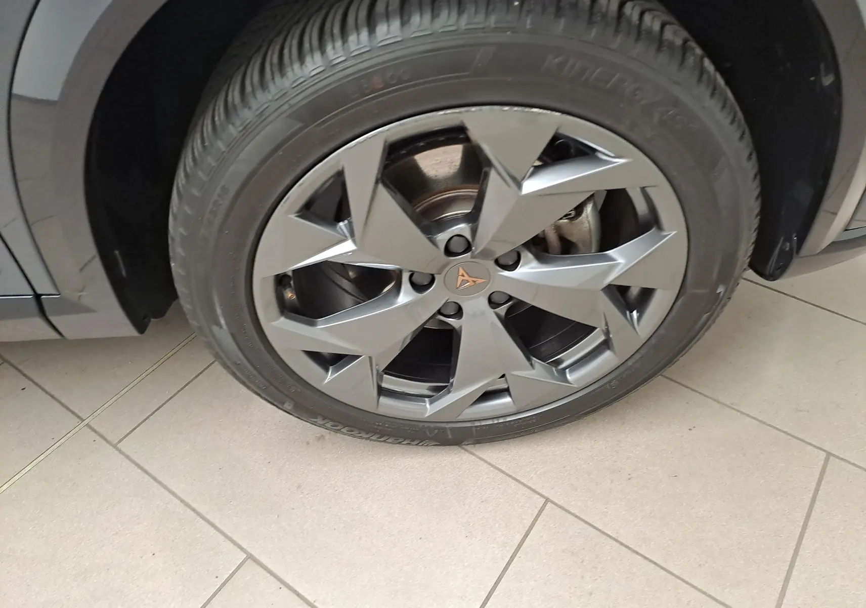 Gros plan sur la jante alliage 18'' Tempest gris du CUPRA Formentor 1.5 eTSI 150 DSG7 avec logo central cuivré.