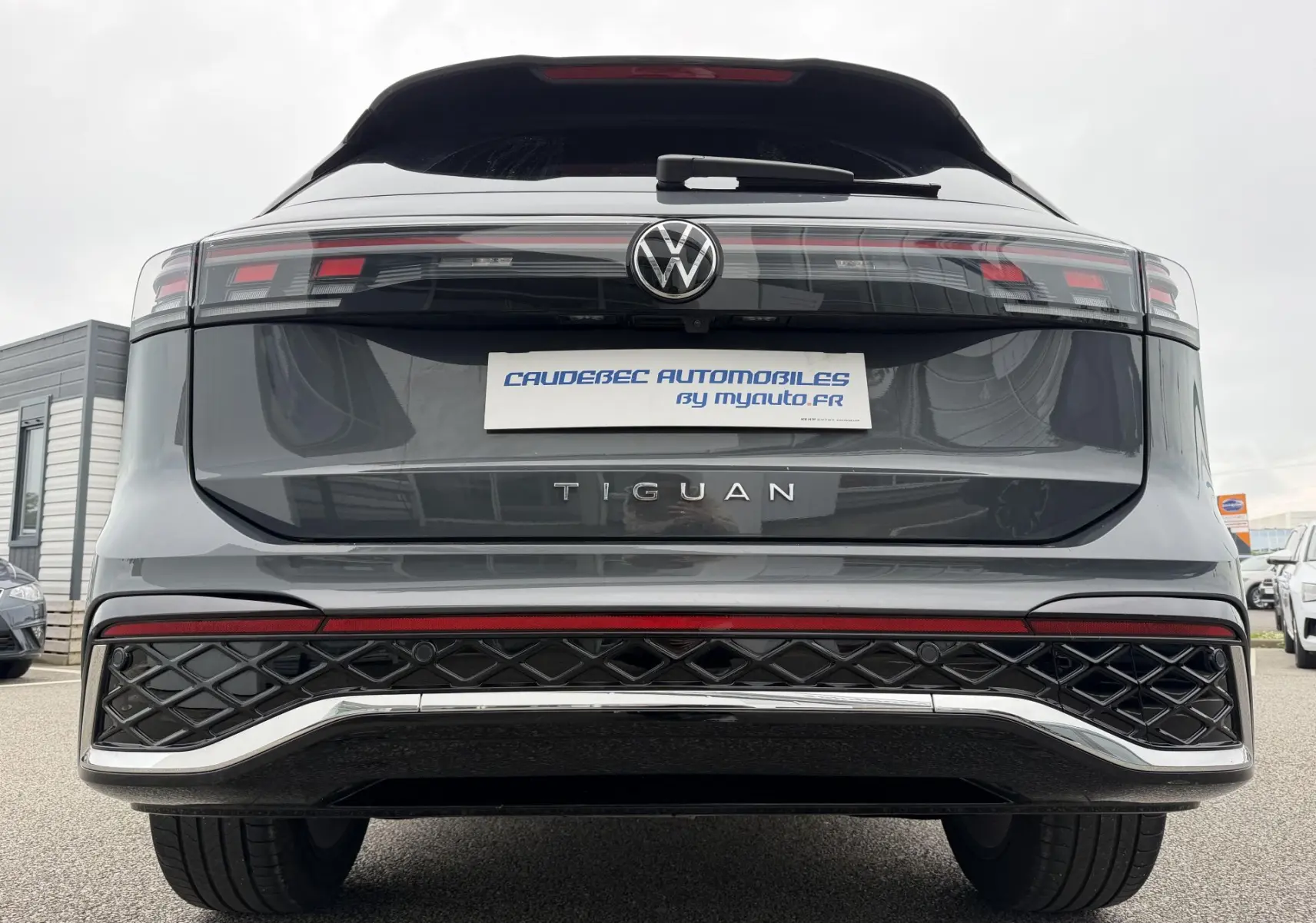 Vue arrière du Volkswagen Tiguan gris métallisé 2025, avec feux arrière LED et logo central visible.
