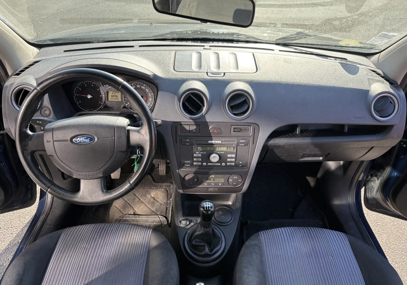 Tableau de bord et volant d'une Ford Fusion 2009 bleu, vue intérieure frontale avec console centrale et sièges avant.
