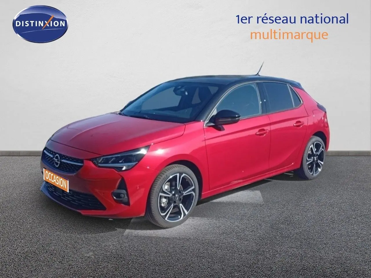 Opel Corsa rouge métallisé avec toit noir vue 3/4 avant droit, jantes alliage noires et phares LED allumés.