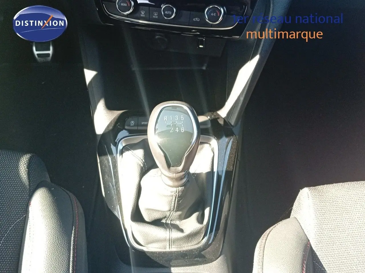 Le levier de vitesses manuel 6 rapports de l'Opel Corsa 1.2 Turbo 2023, entouré de sièges tissu noir.