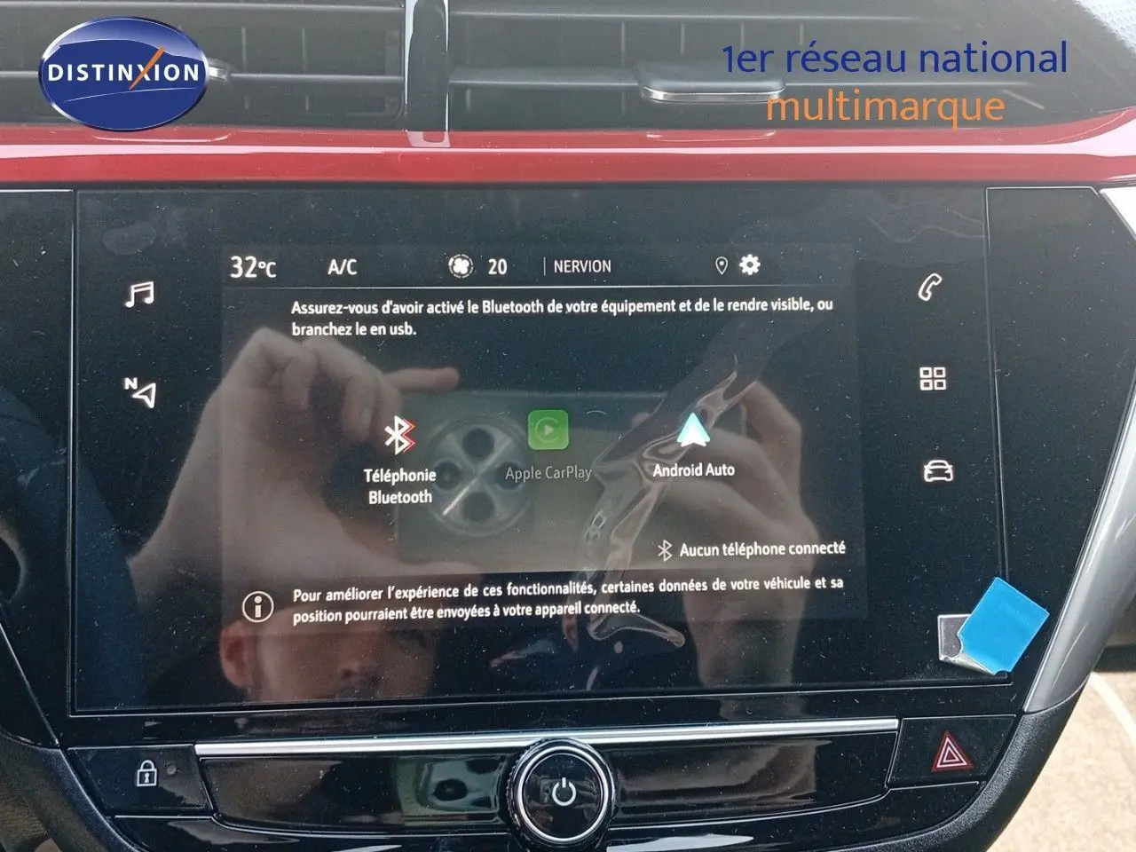 Écran tactile central de la console d'une Opel Corsa rouge métal avec toit noir, affichant les options Bluetooth et Android Auto.