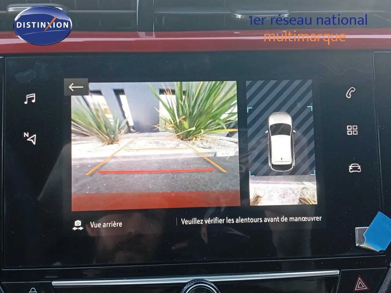 Écran multimédia montrant la caméra de recul et l'affichage 360° de l'Opel Corsa rouge métal toit noir.