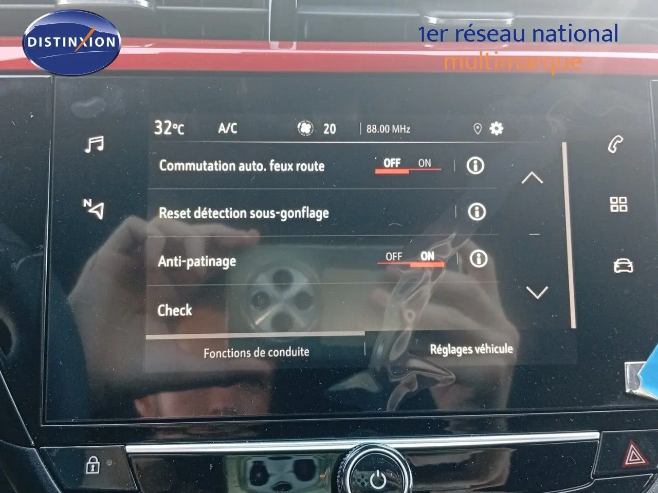 Écran tactile central de l’Opel Corsa rouge métal avec toit noir, affichant les réglages de conduite et sécurité.