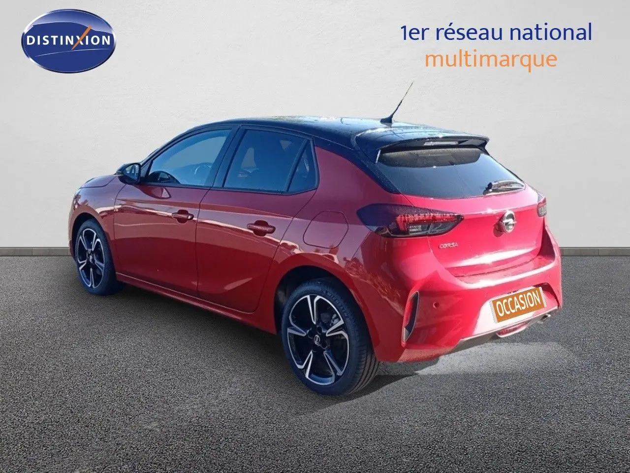 Opel Corsa rouge métal avec toit noir vue 3/4 arrière droit, jantes noires et feux arrière LED.