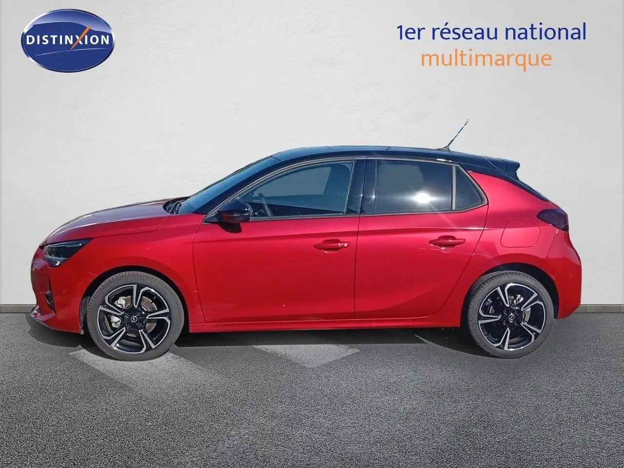 Profil droit d'une Opel Corsa 1.2 Turbo 100ch GS rouge métal avec toit noir et jantes alliage noires.