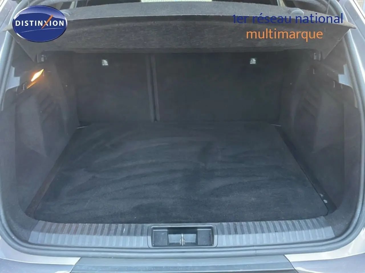 Coffre ouvert de la Renault Symbioz gris cassiopée métal, vue arrière montrant l’espace de chargement vide.