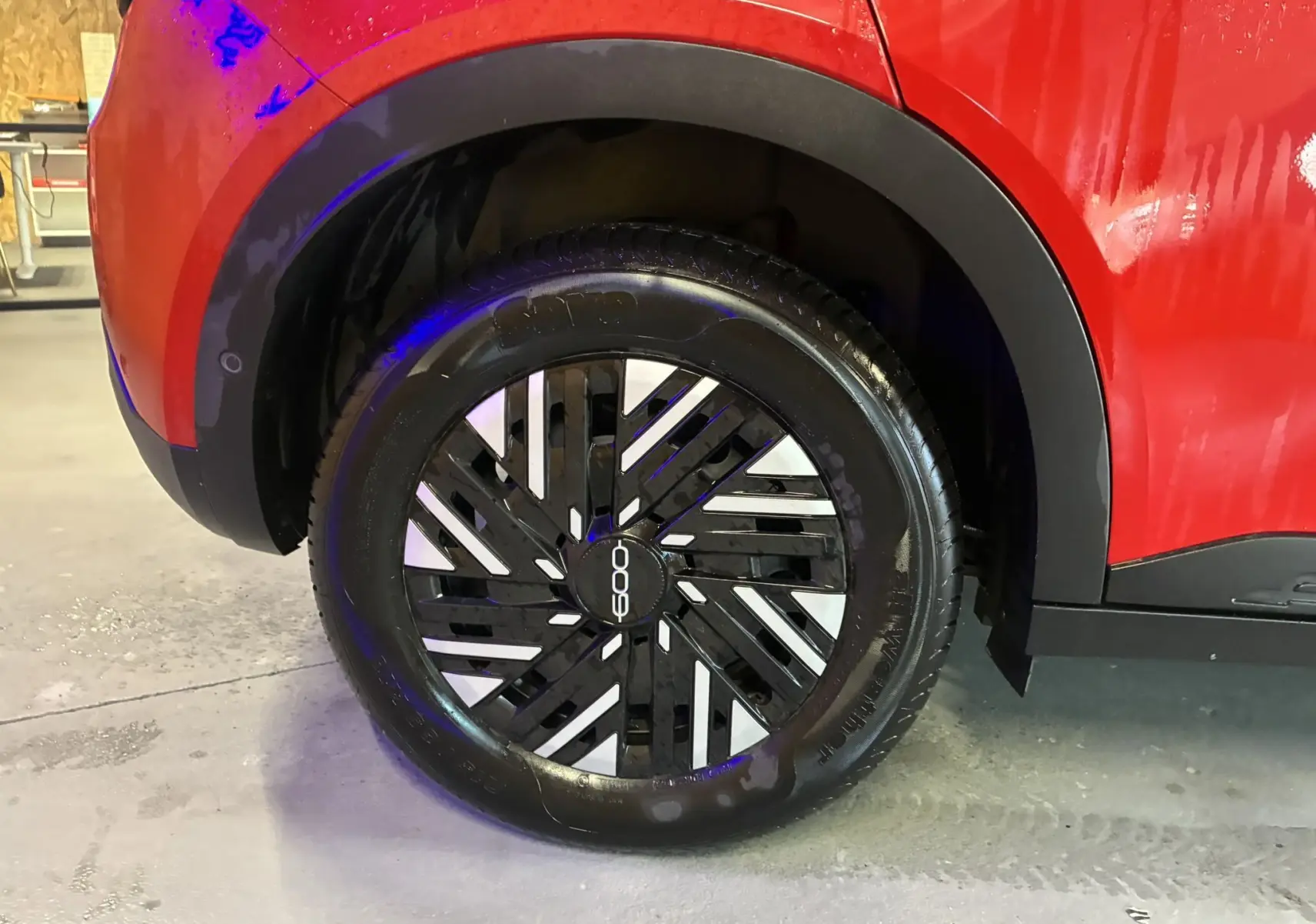 Gros plan sur la roue arrière droite d'une FIAT 600 1.2 HYBRID 100 rouge 2024 avec jante noire et argentée au design moderne.