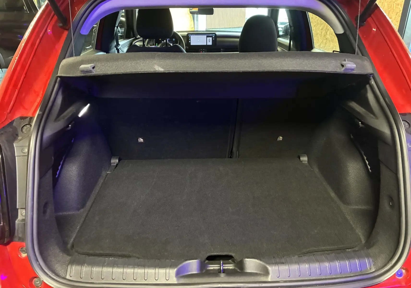Coffre ouvert vu de l'arrière d'une FIAT 600 rouge 2024, intérieur noir avec tablette cache-bagages en place.