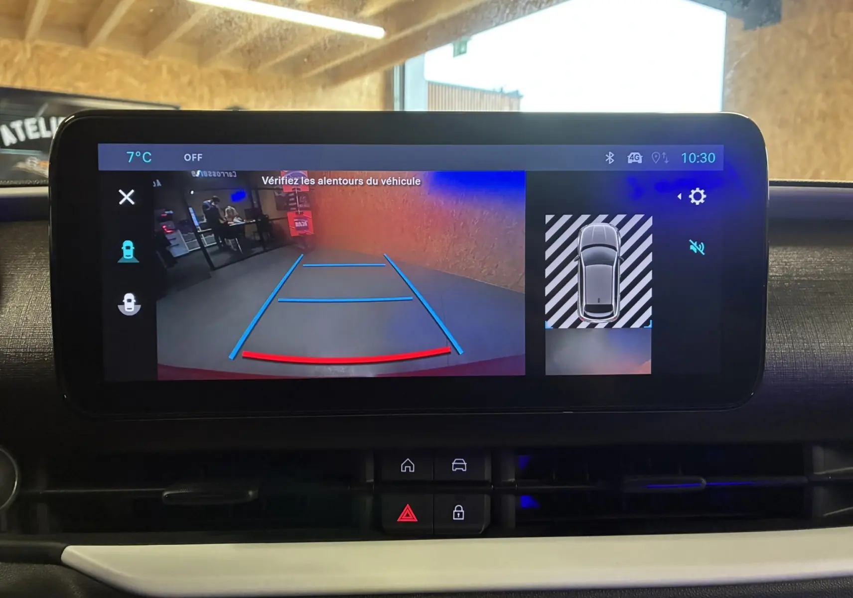 Écran central de la FIAT 600 rouge 2024 montrant la caméra de recul avec guidage de trajectoire en intérieur.