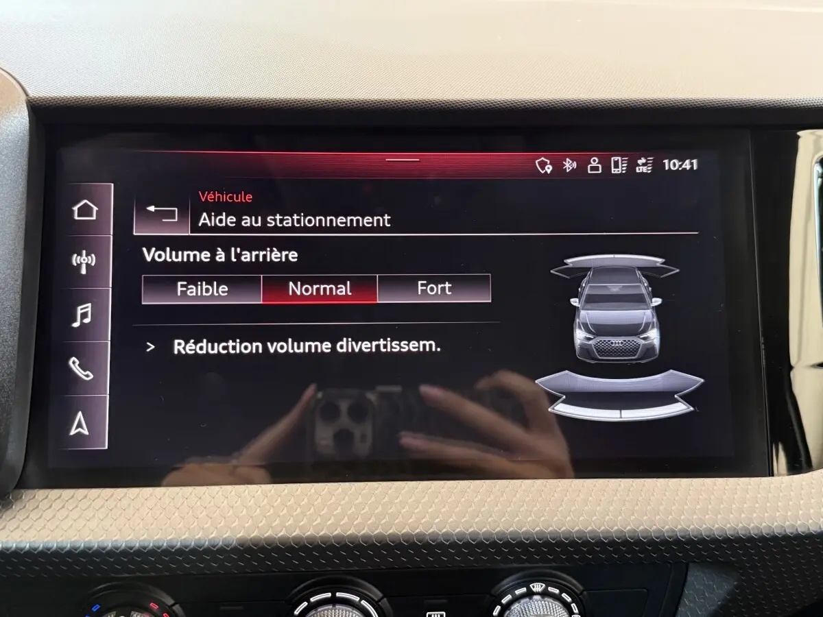 Écran tactile intérieur affichant l'aide au stationnement de l'Audi A1 noire vue de dessus en schéma digital.