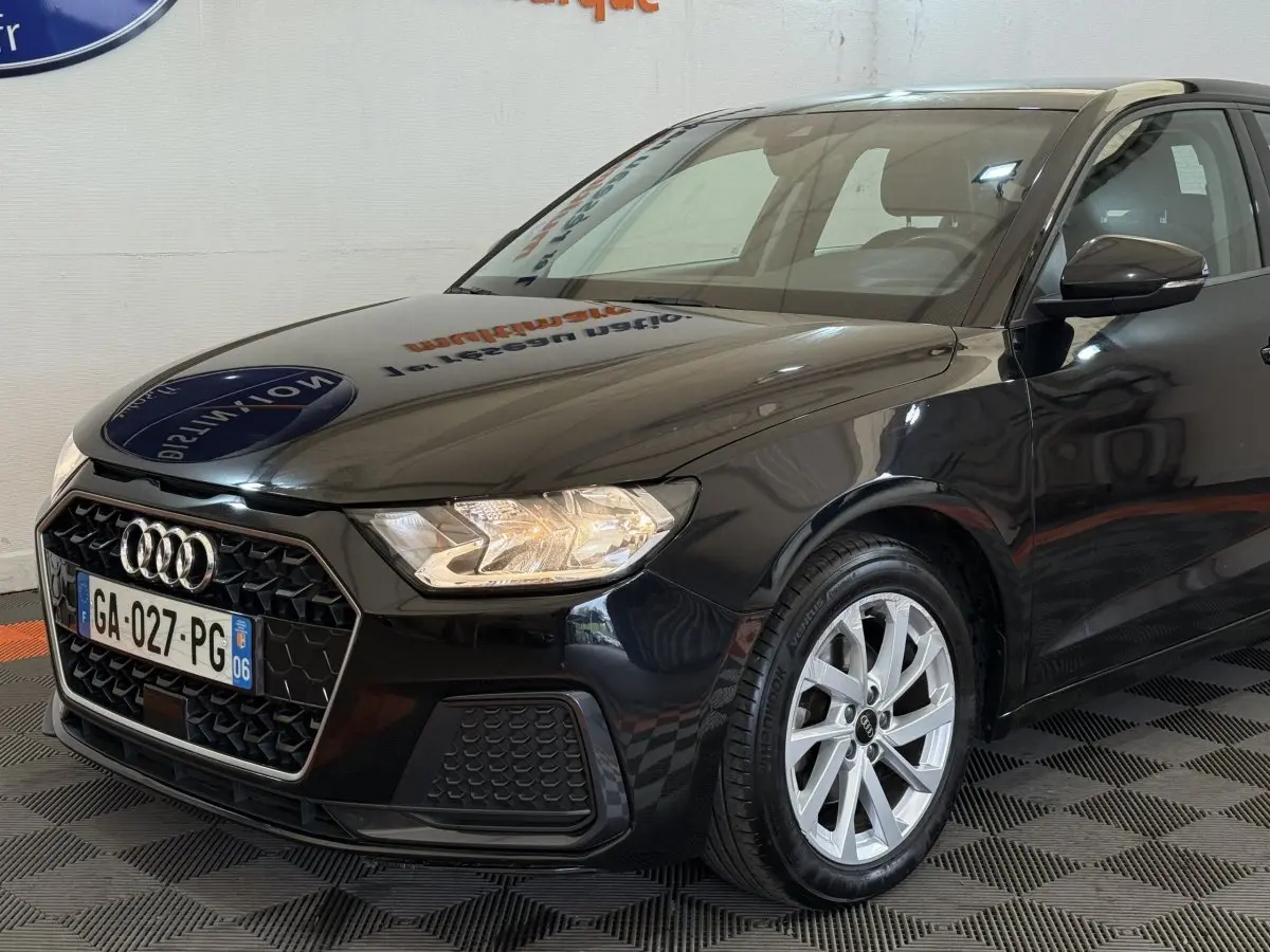 Audi A1 noir vue 3/4 avant droit, avec calandre hexagonale et jantes alliage argentées visibles.