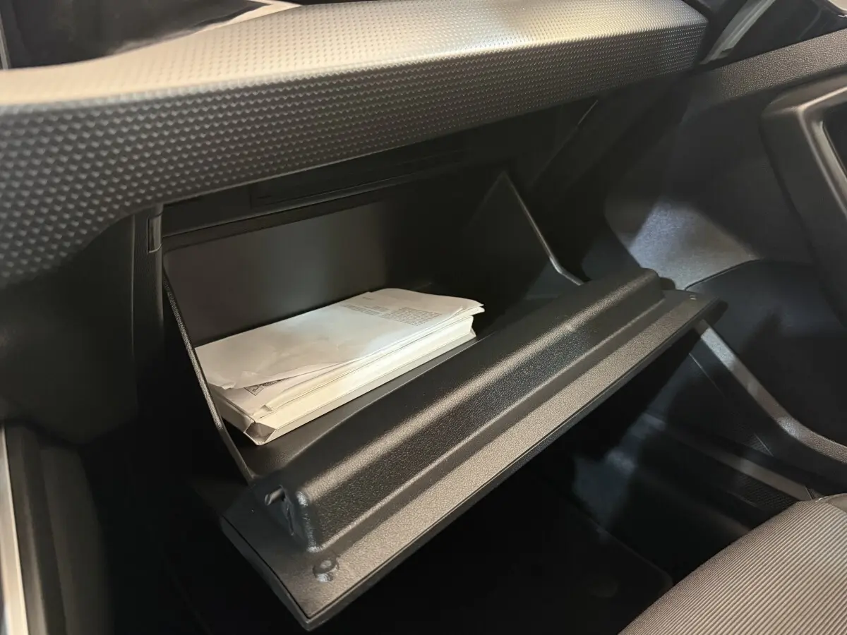 Vue intérieure du vide-poche passager ouvert de l'Audi A1 Business Line 2021, avec documents visibles à l'intérieur.