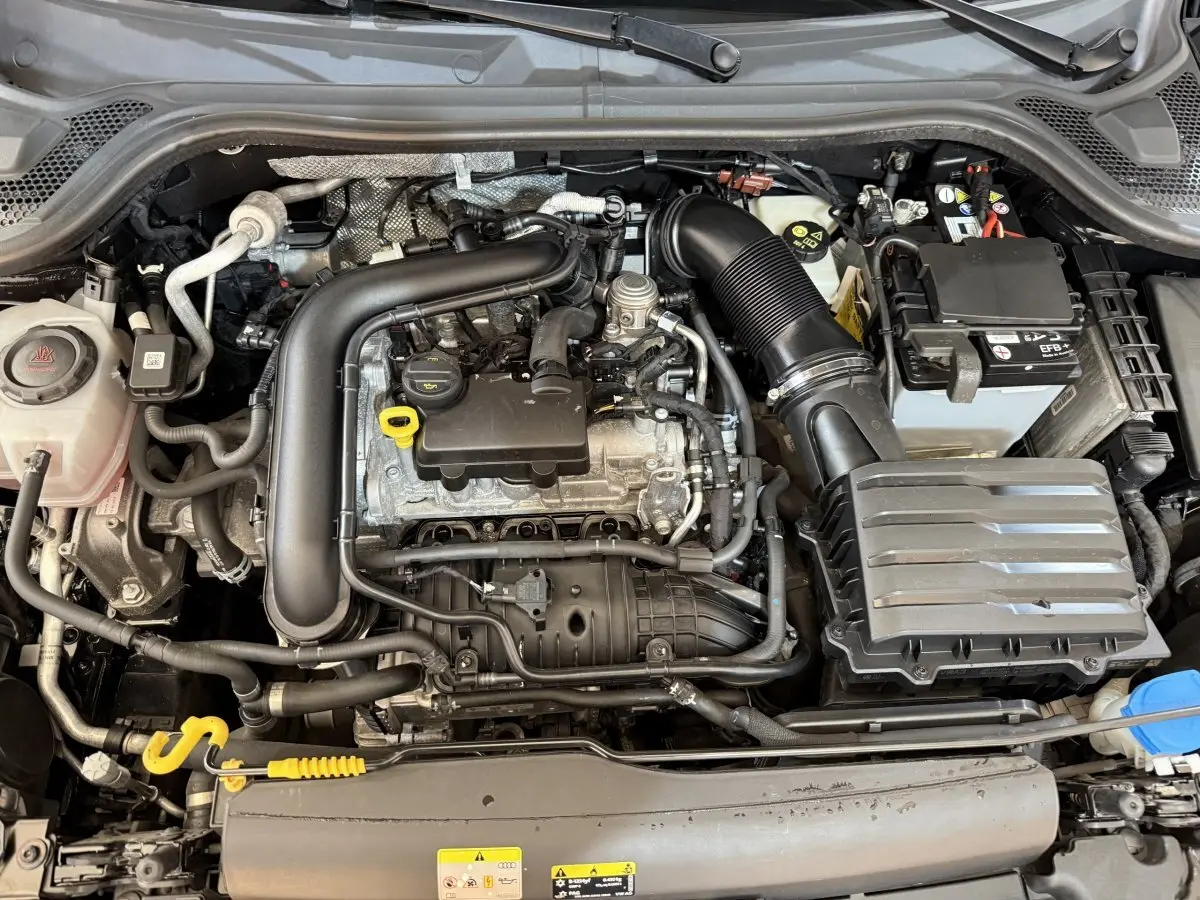 Vue plongeante sur le moteur essence noir et gris de l'Audi A1 1.0 TFSI 110 S tronic 7 Business Line de 2021.