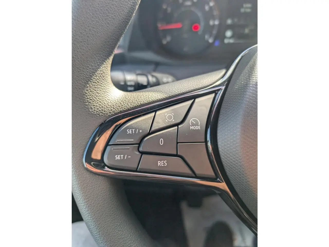 Gros plan sur les commandes de régulateur de vitesse au volant noir du Renault Master IV blanc de 2025.