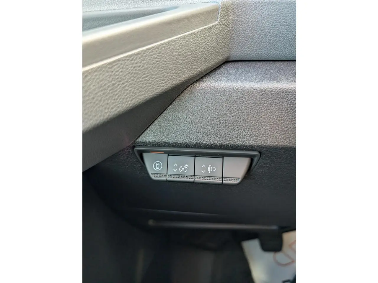 Gros plan sur les commandes de réglage des phares et du tableau de bord du Renault Master blanc 2025, côté gauche.