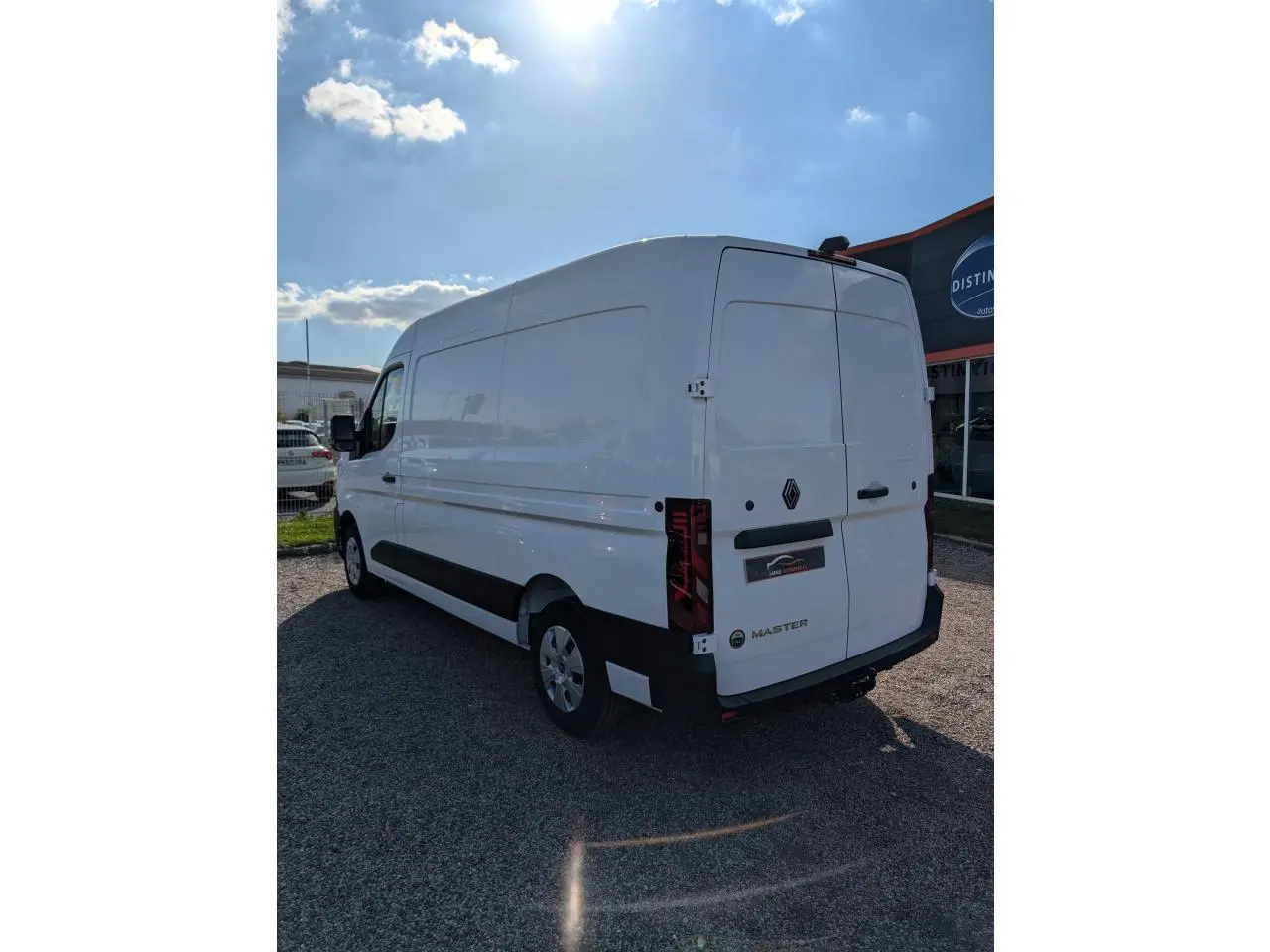 Renault Master blanc vu en 3/4 arrière droit, avec porte latérale coulissante et attelage visible.