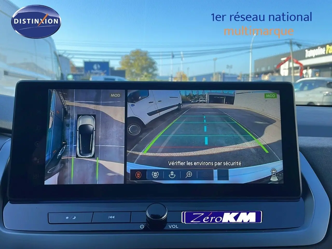 Écran multimédia du Nissan Qashqai blanc nacré, affichant la caméra de recul avec vue 360° et lignes de guidage.