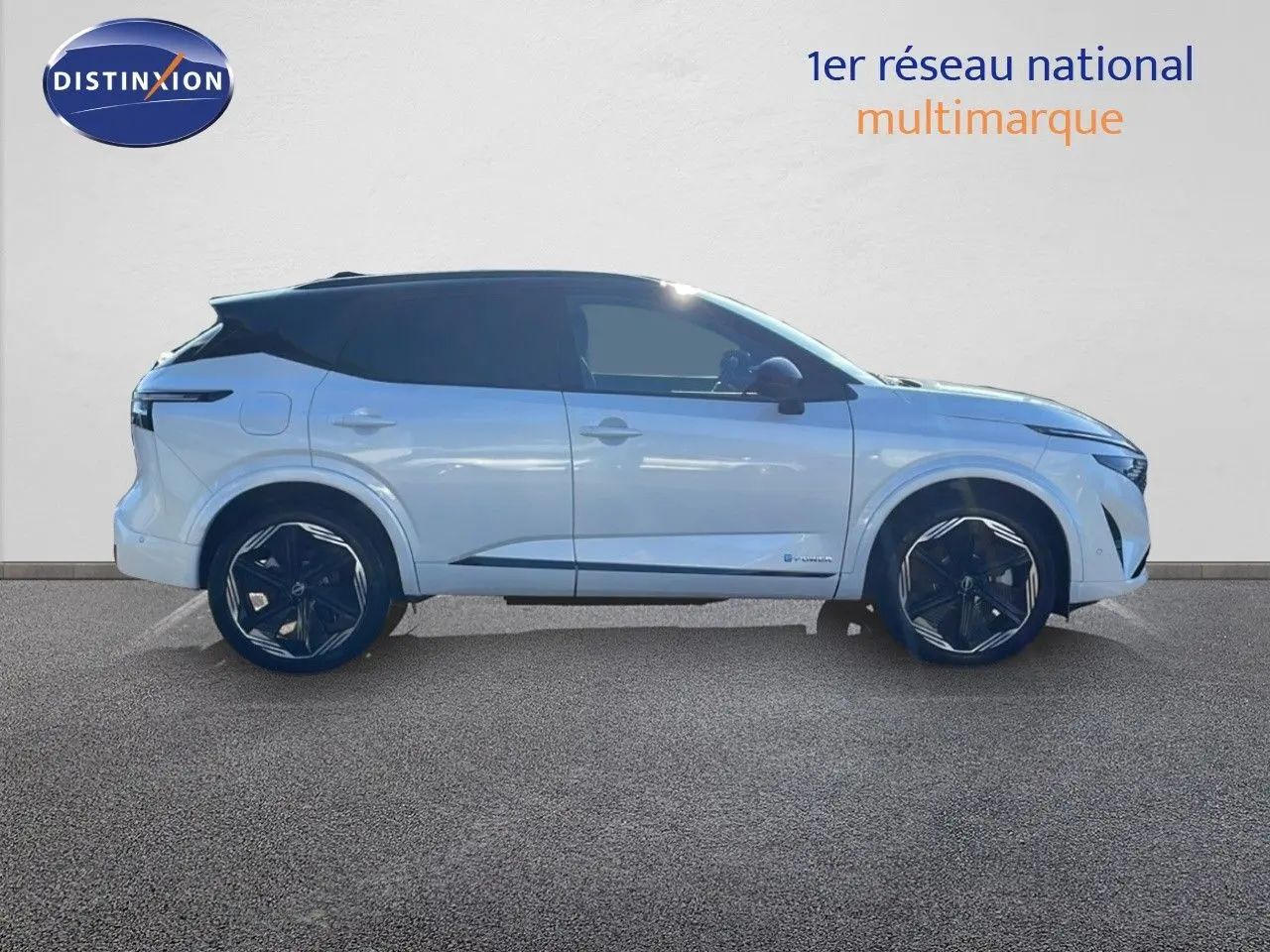 Profil côté gauche du Nissan Qashqai blanc nacré avec toit noir, roues noires et lignes modernes visibles.