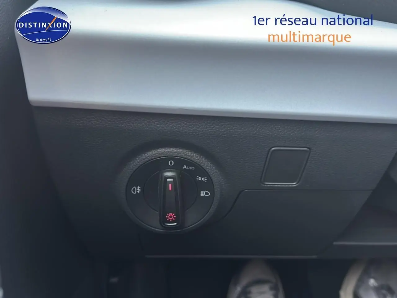 Gros plan sur le bouton de commande des phares dans l’habitacle du SEAT Arona bleu saphir 2025.
