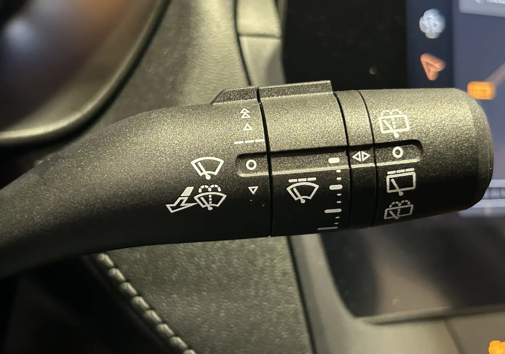 Gros plan sur la commande de l’essuie-glace noir à l’intérieur du MG ZS Cosmic Silver, montrant les pictogrammes de réglage.