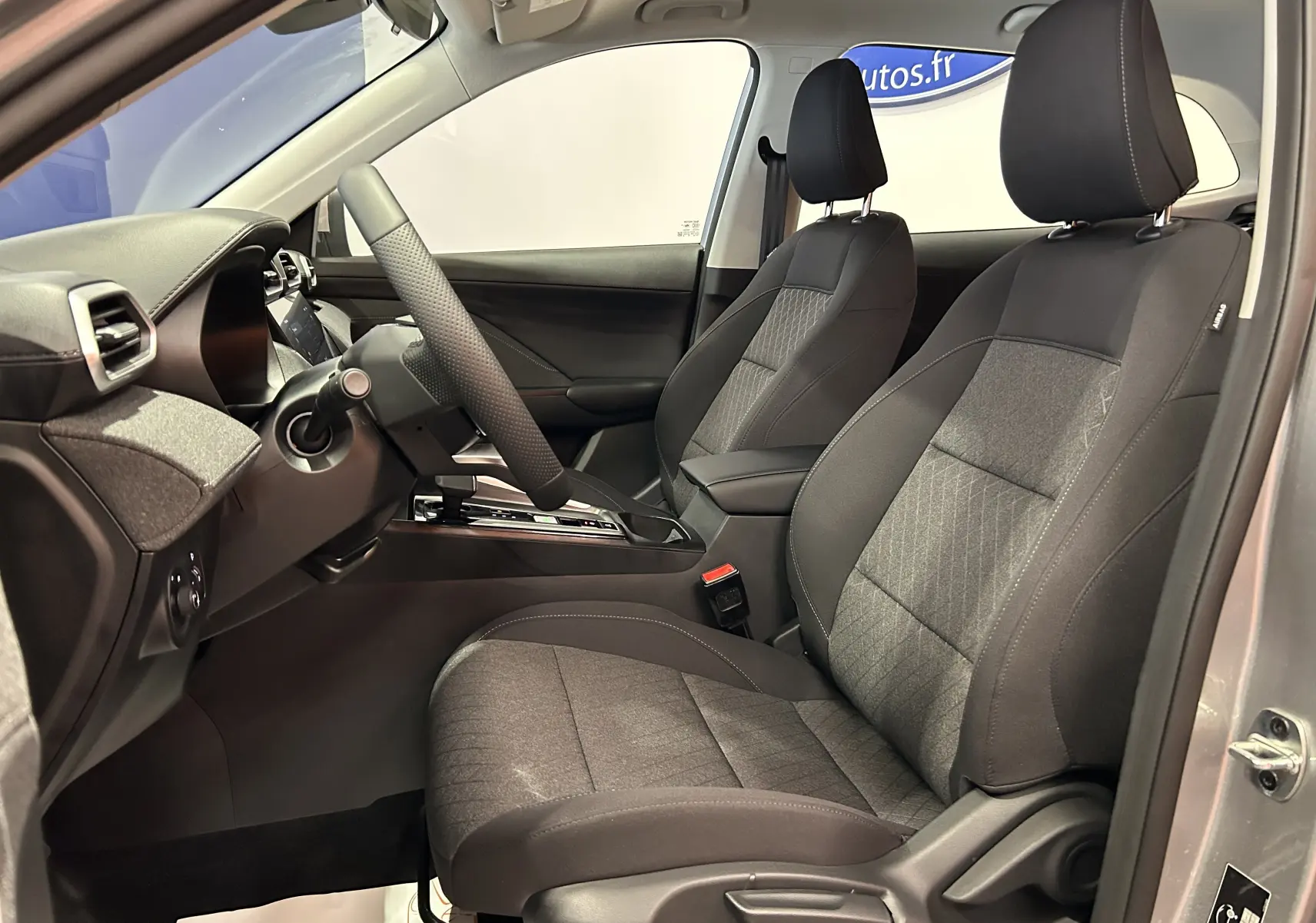 Intérieur du MG ZS 1.5 L Hybrid+ 2025 en Cosmic Silver, vue côté conducteur montrant sièges tissu et console centrale.