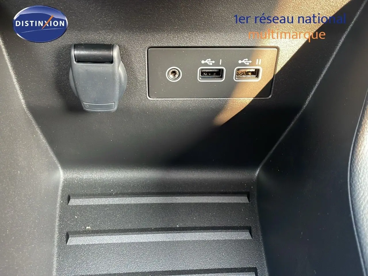 Prise USB et prise jack sur la console centrale d'une Renault Clio gris schiste métal, vue rapprochée intérieure.
