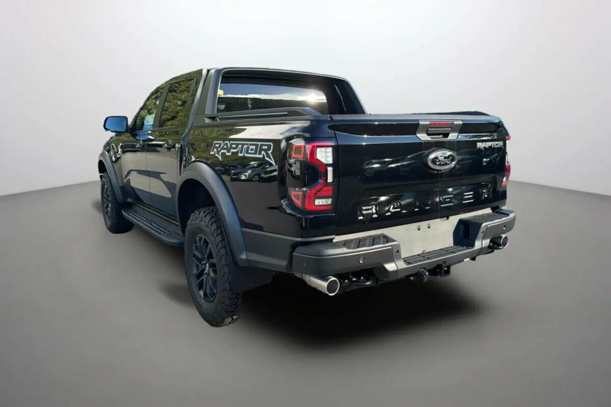 Vue 3/4 arrière gauche du Ford Ranger Raptor 2024 noir absolu avec logo distinctif et double sortie d'échappement.