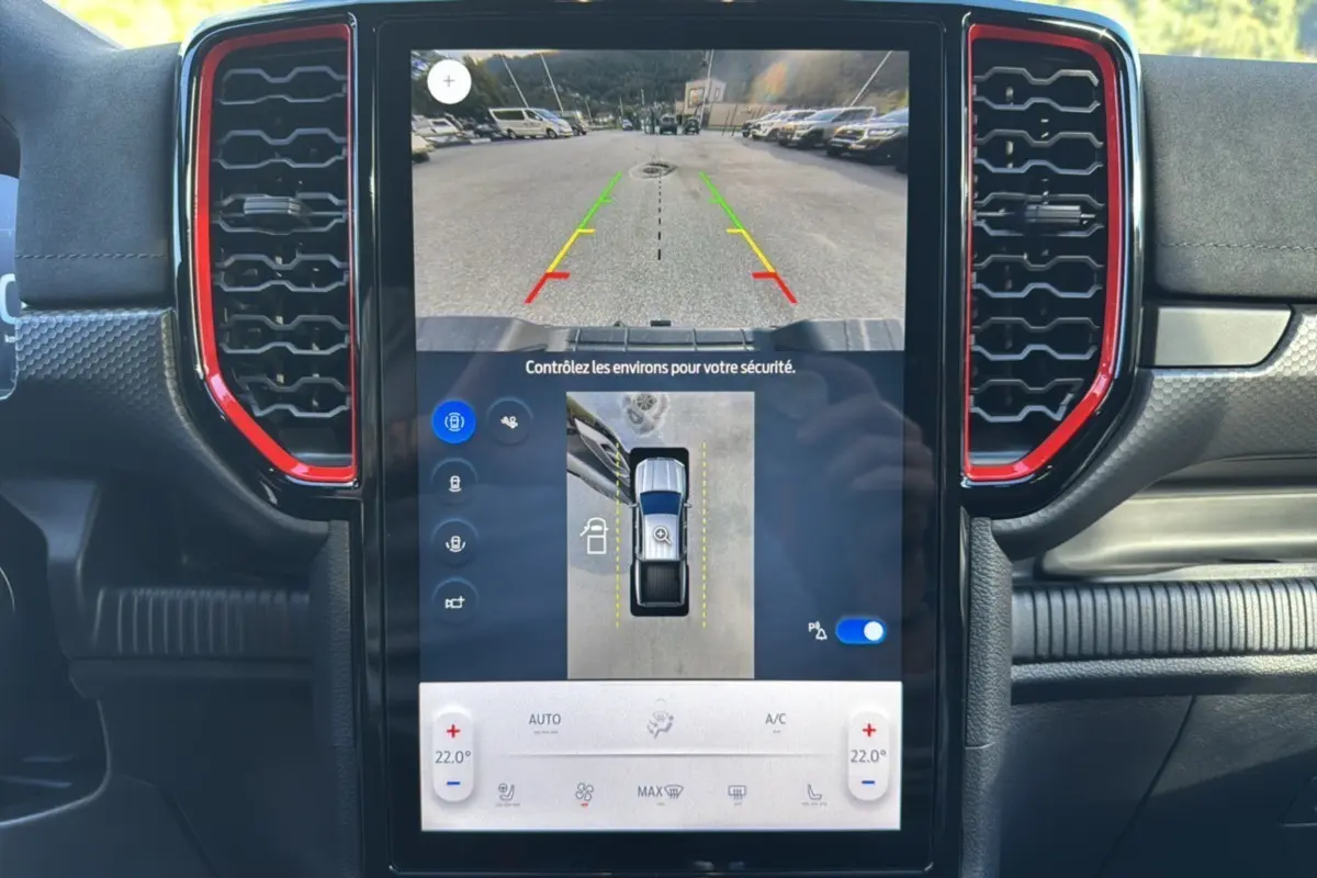 Écran central du Ford Ranger Raptor 2024 montrant la caméra de recul, entouré de grilles d'aération avec contours rouges.