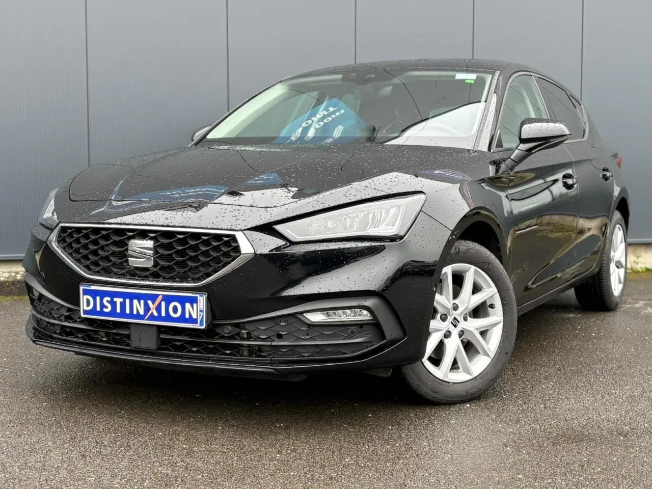 SEAT Leon 2024 noir Minuit vue 3/4 avant gauche, jantes alliage argent et calandre hexagonale distinctive.