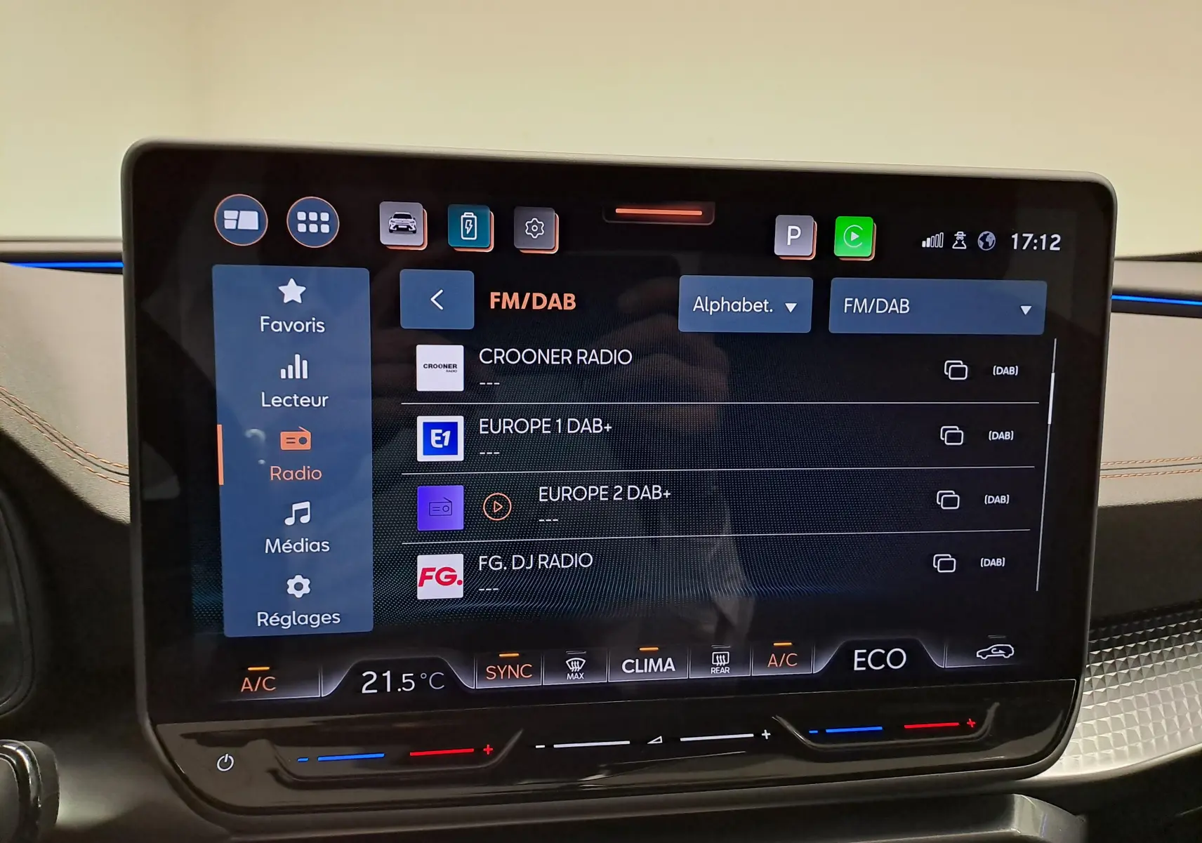 Écran tactile central HD 12,9'' du CUPRA Formentor 2025 affichant les stations radio FM/DAB, avec commandes climatisation en dessous.