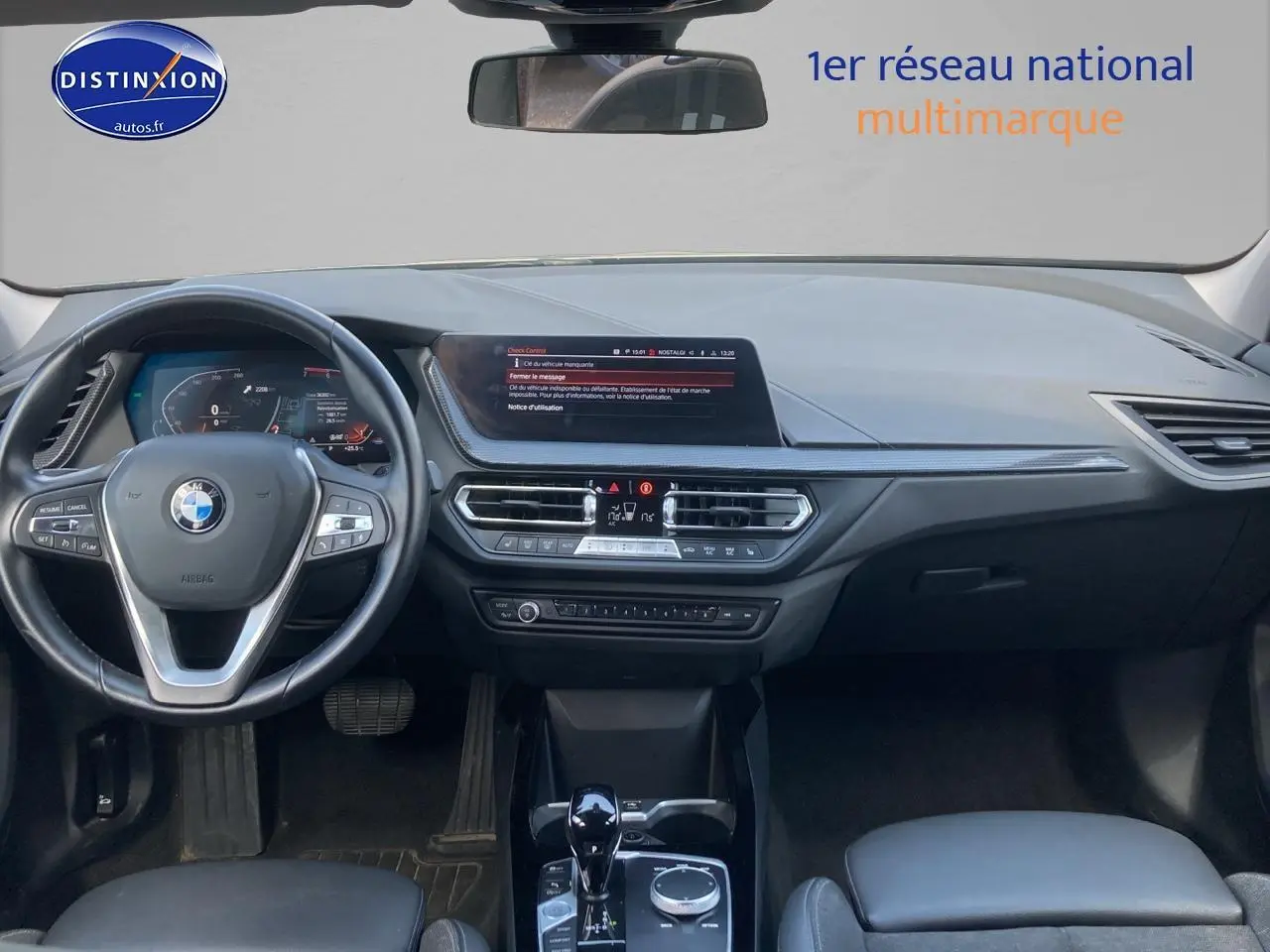 Vue intérieure du tableau de bord et volant noir de la BMW Série 1 F40 118i 2023 avec écran central et commandes multifonctions.