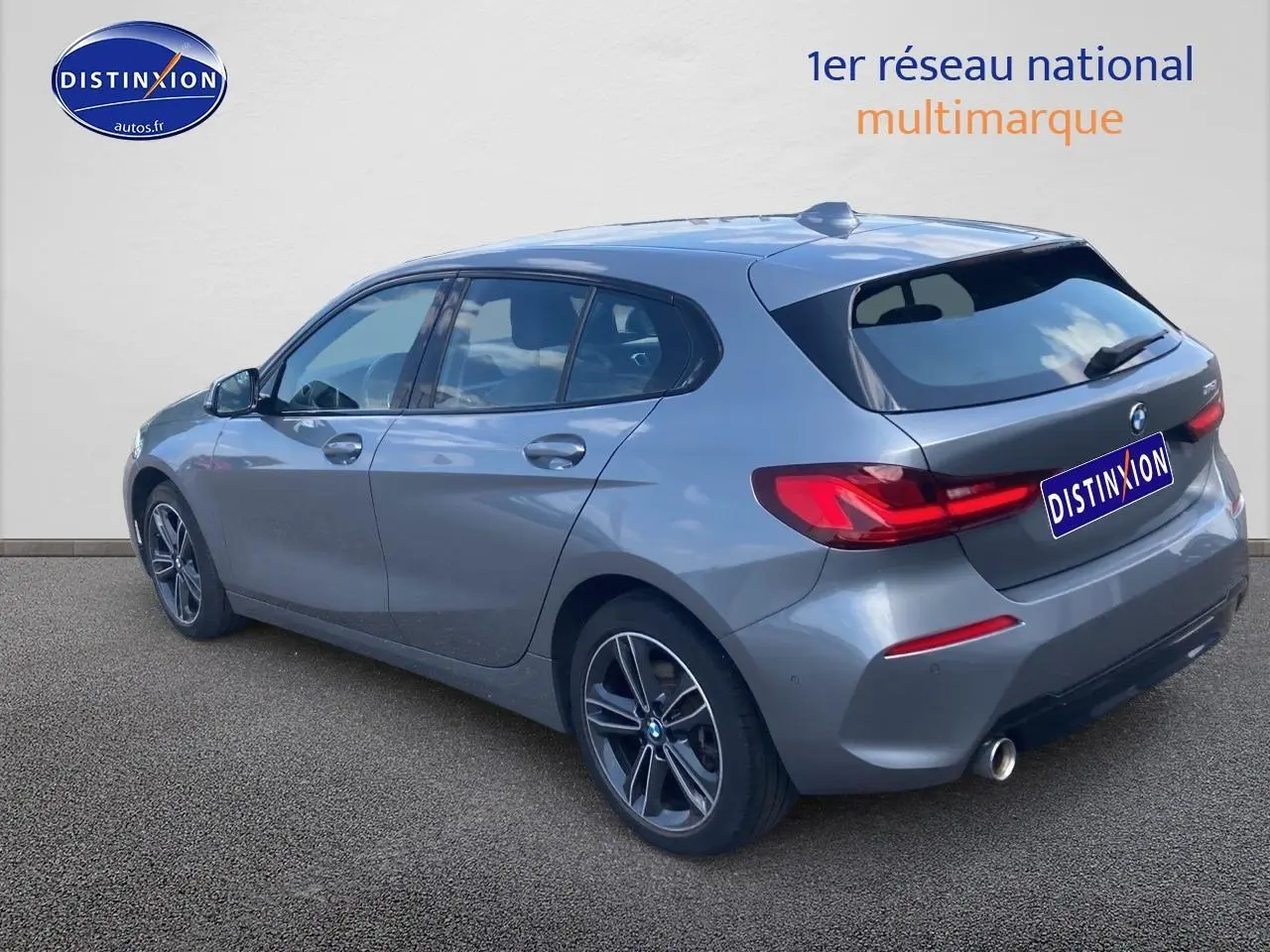 BMW Série 1 gris foncé vue 3/4 arrière côté gauche avec jantes alliage et feux arrière LED distinctifs