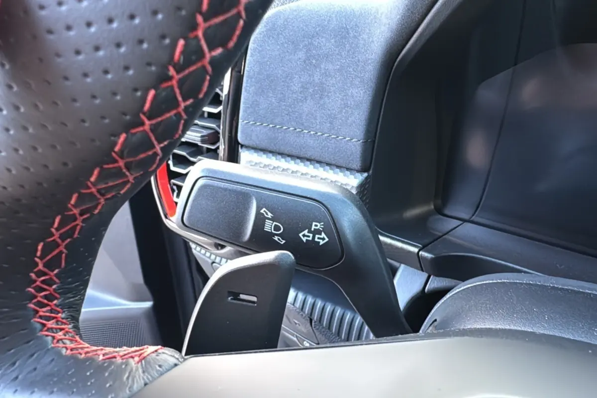 Gros plan sur le volant en cuir noir avec surpiqûres rouges et la commande des clignotants du Ford Ranger Raptor 2024.