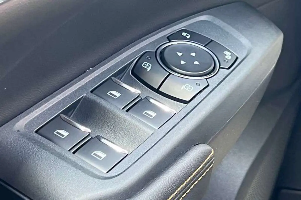 Gros plan sur les commandes des vitres et rétroviseurs côté conducteur du Ford Ranger Wildtrak noir agate 2025.