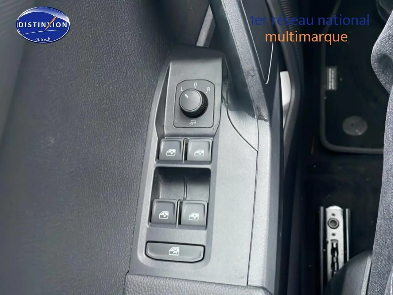 Vue rapprochée des commandes de lève-vitres et rétroviseurs côté conducteur du SEAT Arona blanc Nevada 2025.