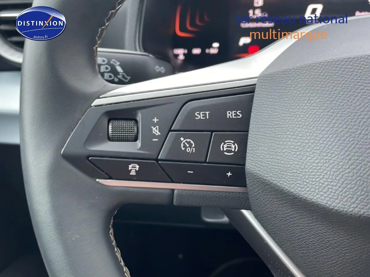 Gros plan sur les commandes de régulateur de vitesse au volant cuir du SEAT Arona blanc Nevada 2025.