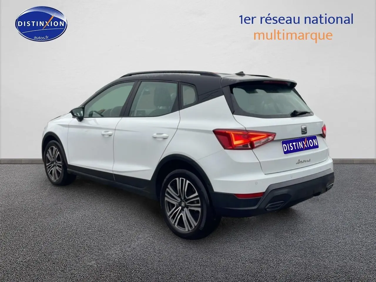 Vue 3/4 arrière droite d'un SEAT Arona blanc Nevada avec toit noir et jantes 17 pouces Urban Design.