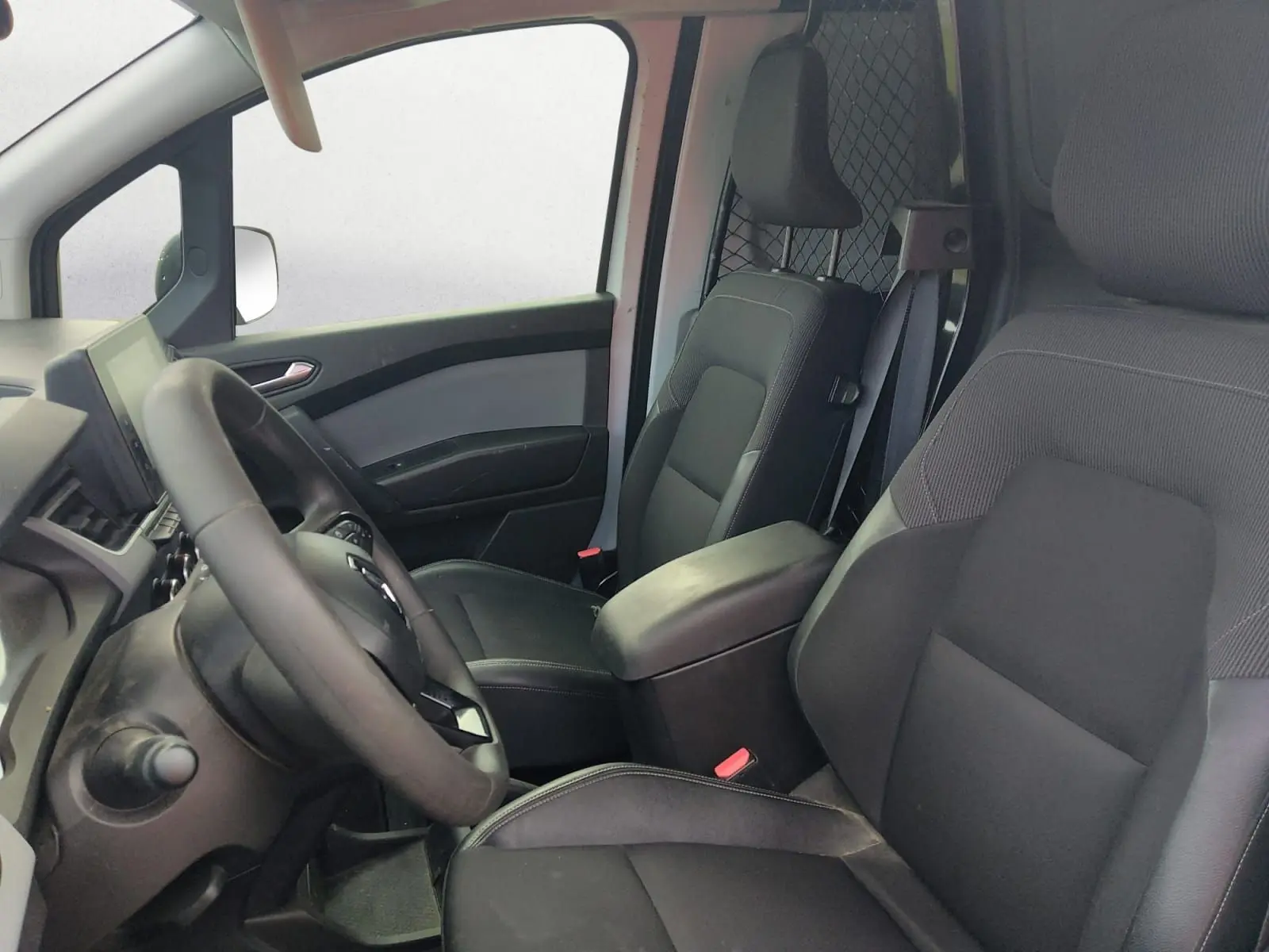 Intérieur du Renault Kangoo 2022 vu côté conducteur, sièges noirs avec cloison pivotante en arrière-plan.