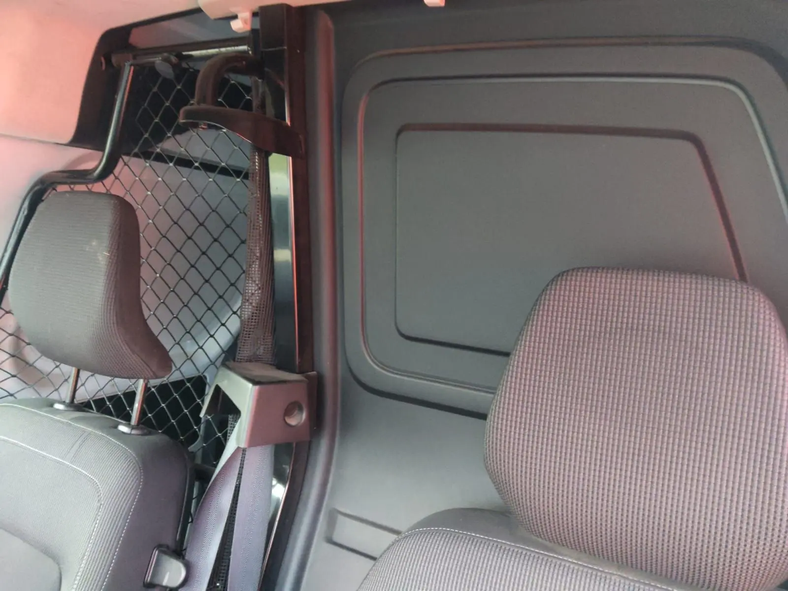 Vue intérieure côté droit du Renault Kangoo 2022, montrant la cloison pivotante et les sièges gris foncé.