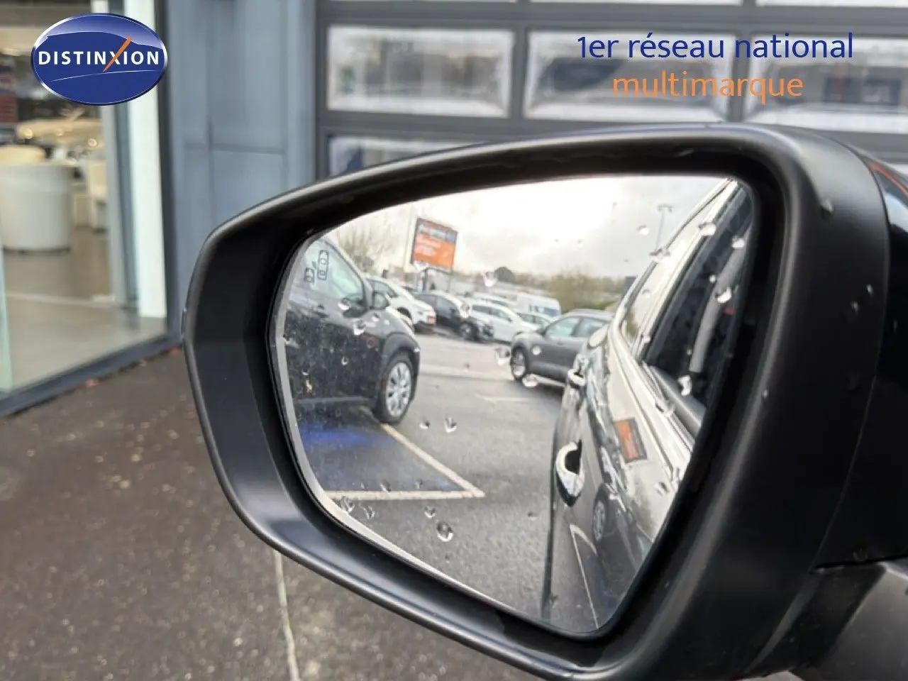 Rétroviseur côté droit montrant la carrosserie gris platinium métal du Citroën C5 Aircross 2025 en hybride, avec gouttes de pluie visibles.