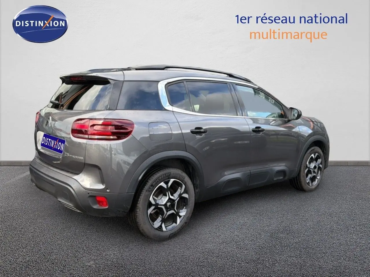 Vue 3/4 arrière droite d’un Citroën C5 Aircross gris platinium métallisé avec toit noir et jantes bi-ton.