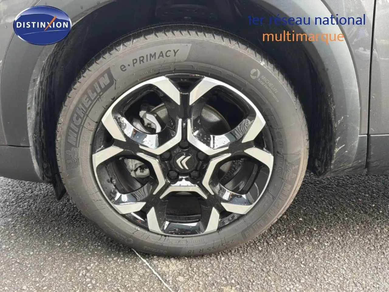 Gros plan sur la roue avant gauche du Citroën C5 Aircross gris platinium métal avec jante alliage noire et argentée.