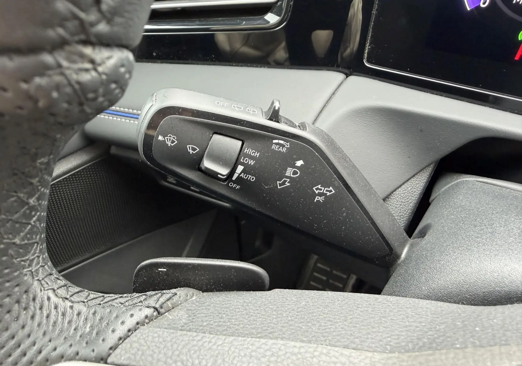 Gros plan sur la manette de commande des essuie-glaces et clignotants du Volkswagen Tiguan 2025, intérieur noir.