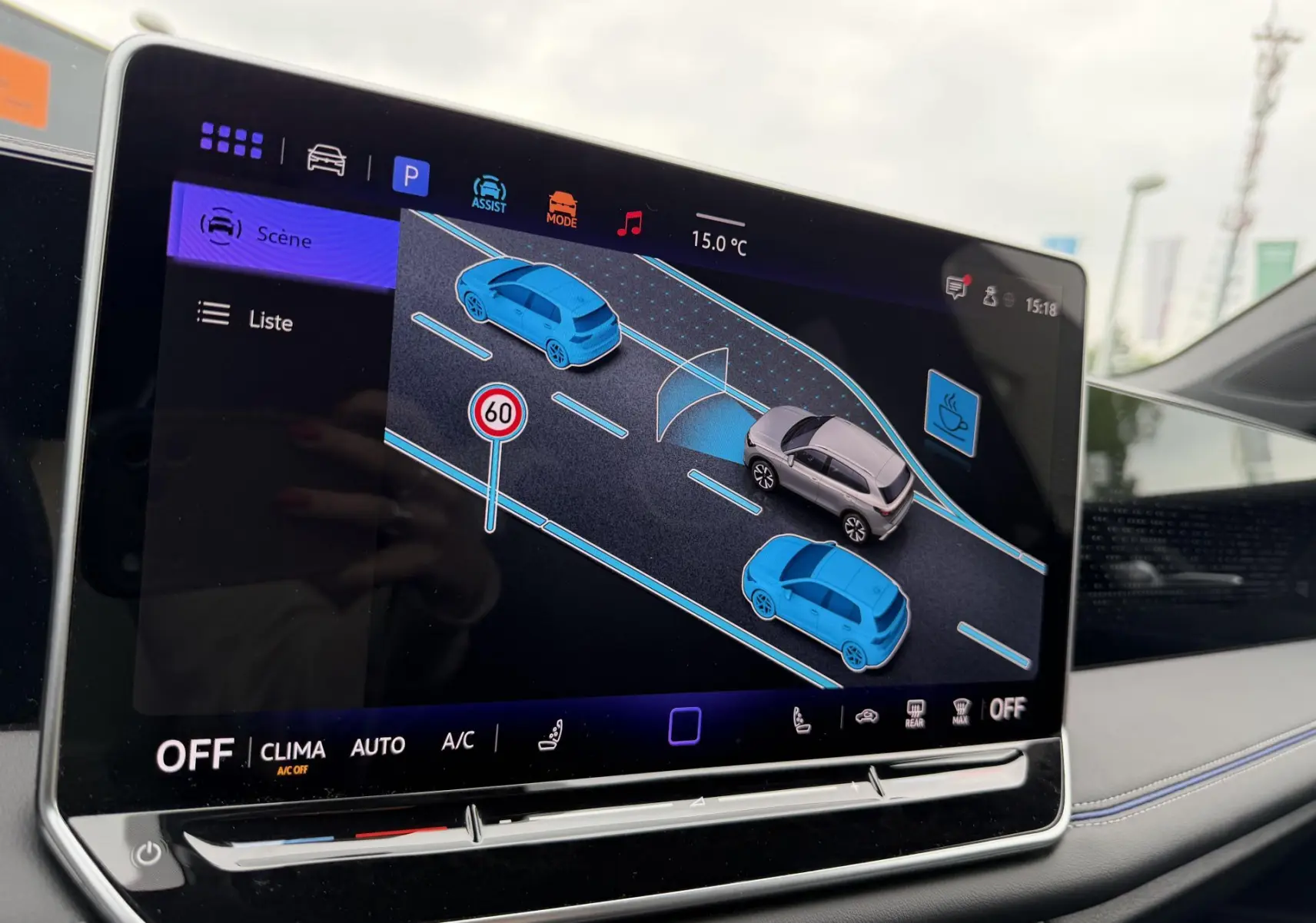 Écran tactile intérieur du Volkswagen Tiguan 2025 montrant l'assistance au stationnement avec vue digitale du véhicule gris.