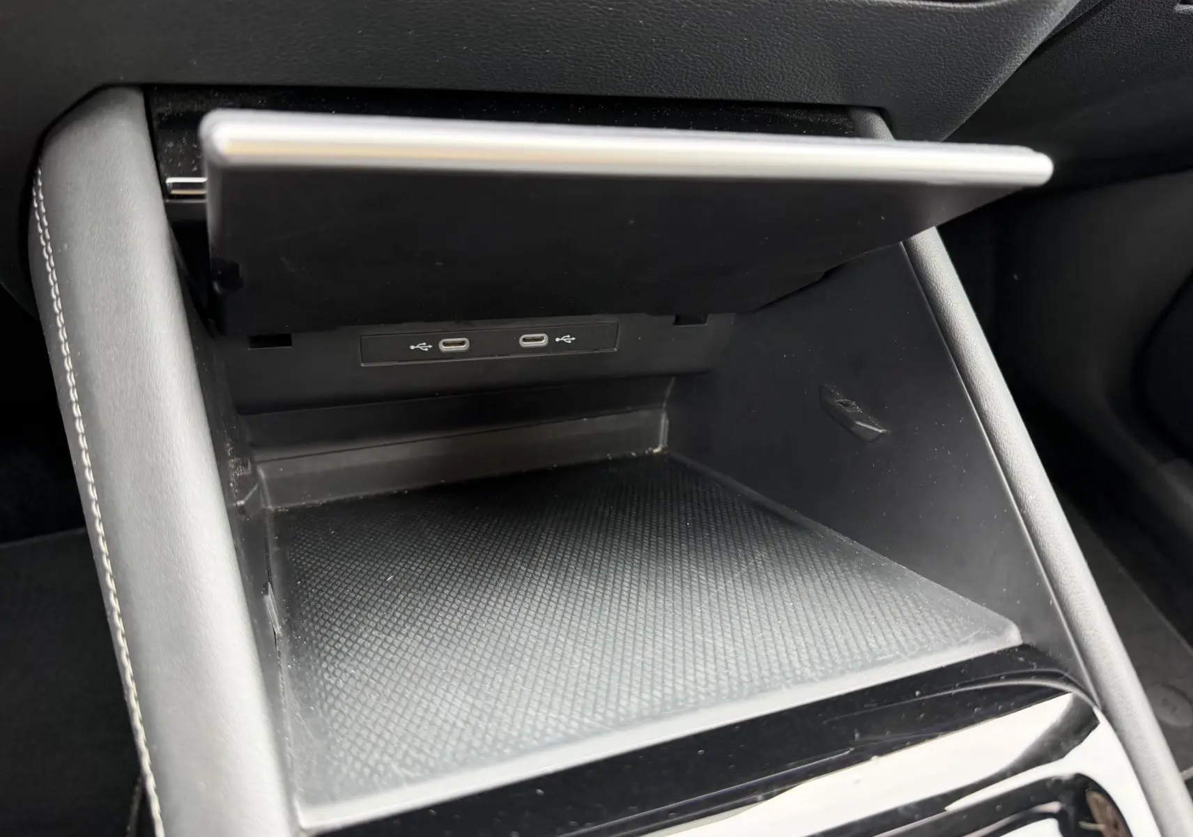 Vue rapprochée de la console centrale du Volkswagen Tiguan 2025, avec compartiment ouvert et ports USB visibles.