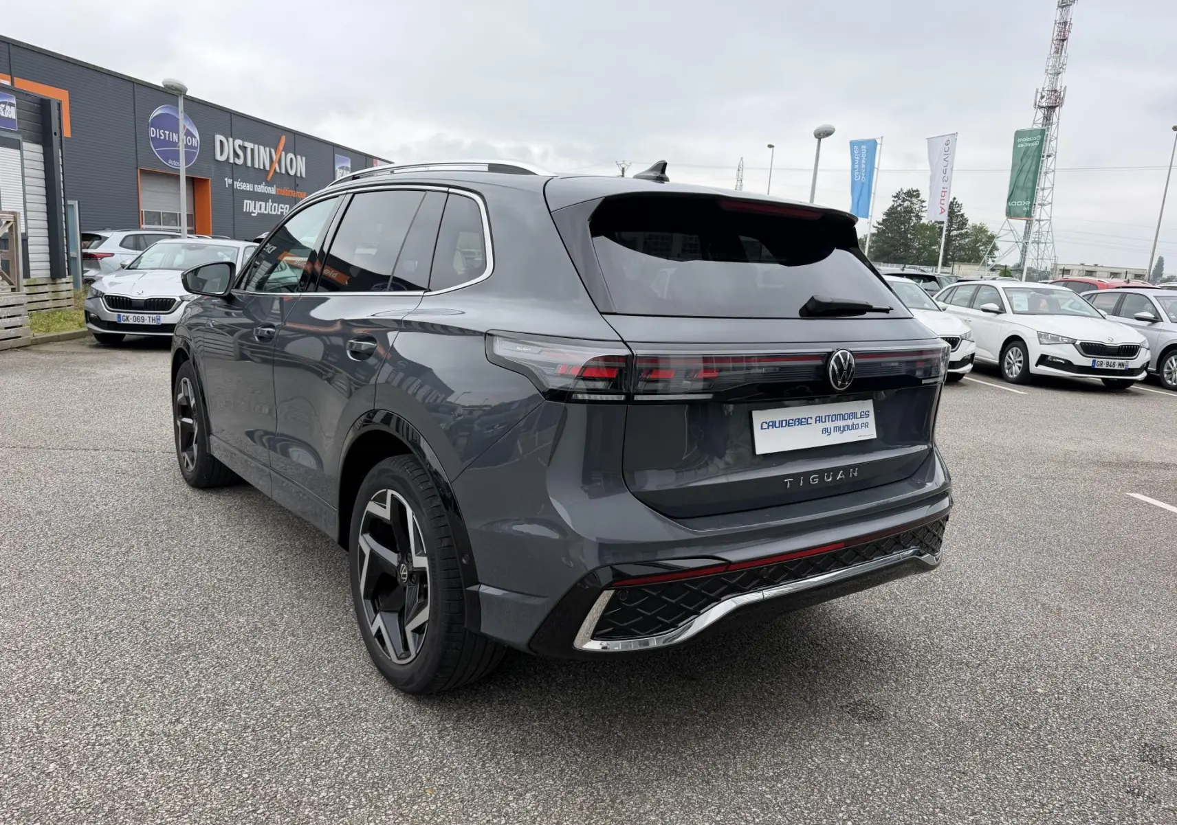 Vue 3/4 arrière droite du Volkswagen Tiguan gris 2025 avec jantes alliage 19 pouces et feux arrière LED 3D.