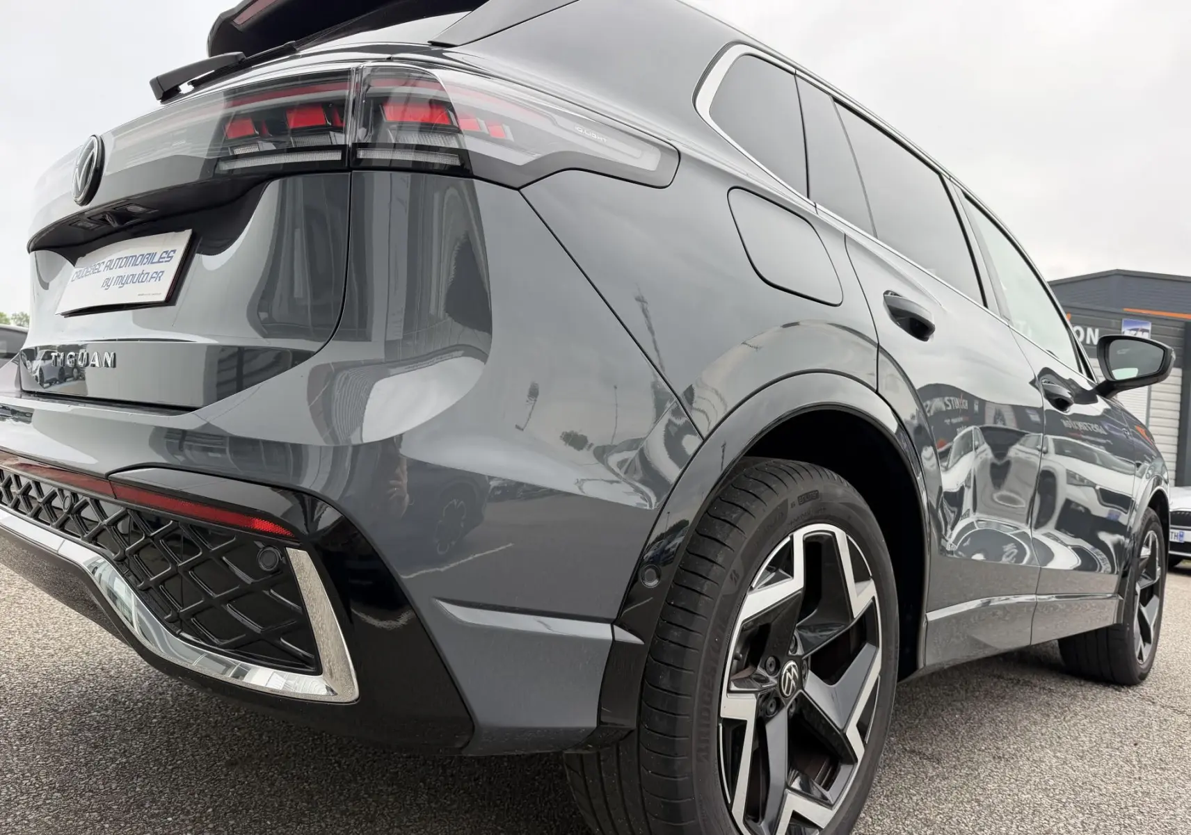 Vue 3/4 arrière droite du Volkswagen Tiguan gris 2025 avec jantes alliage 19 pouces et feux arrière LED 3D.