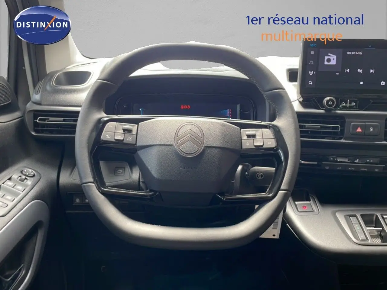 Vue intérieure centrée sur le volant noir d’un Citroën Berlingo 2026 avec tableau de bord et écran tactile.