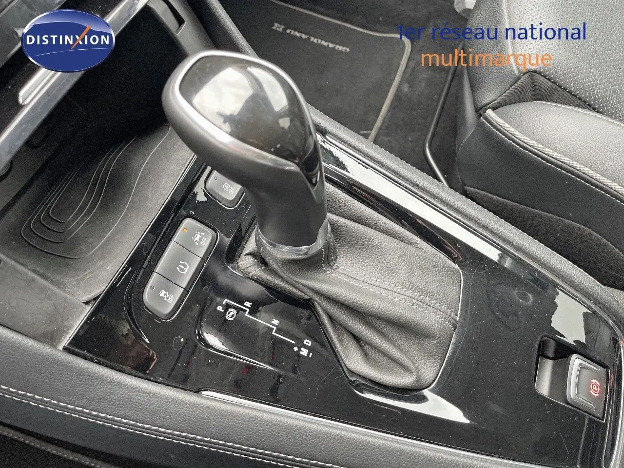 Gros plan sur la console centrale de l’Opel Grandland X 2018 avec levier de vitesse automatique et sellerie noire.